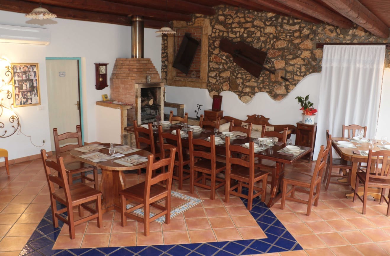 Il ristorante dell'Aranceto con camino in pietra e tavola apparecchiata