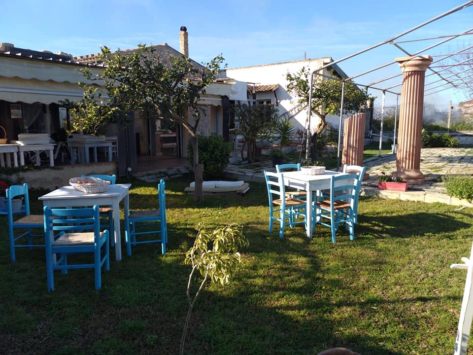 Area ristorante all'aperto con sedie colorate nel giardino dell'Aranceto