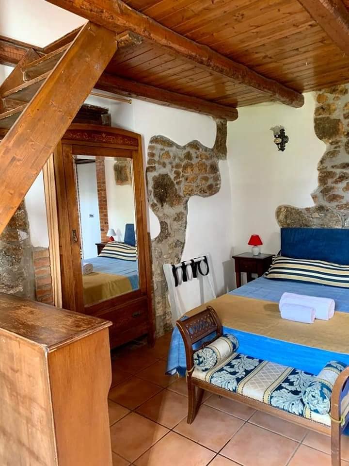 Camera Aretusa con letto matrimoniale e arredi in legno scuro stile '800 siciliano