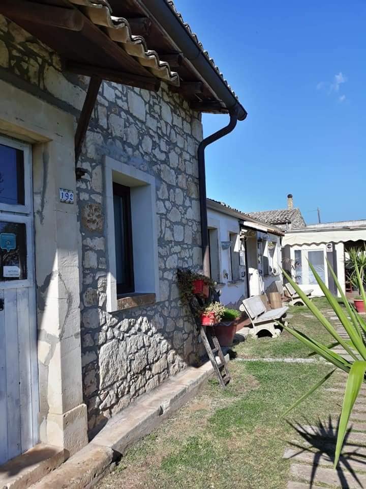 Dettaglio della facciata in pietra del casale con piante mediterranee